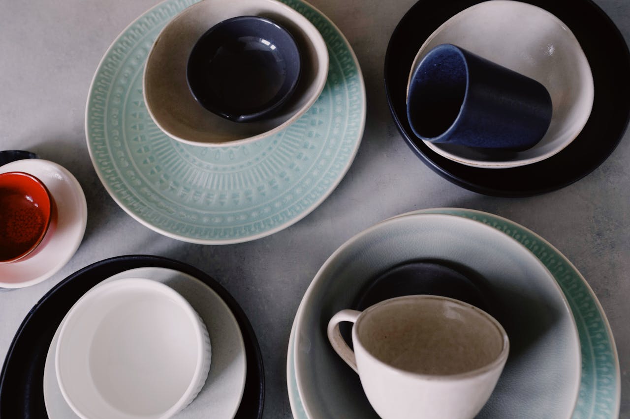 A top-view shot of various ceramic tableware items in mixed colors and patterns, highlighting elegant design.