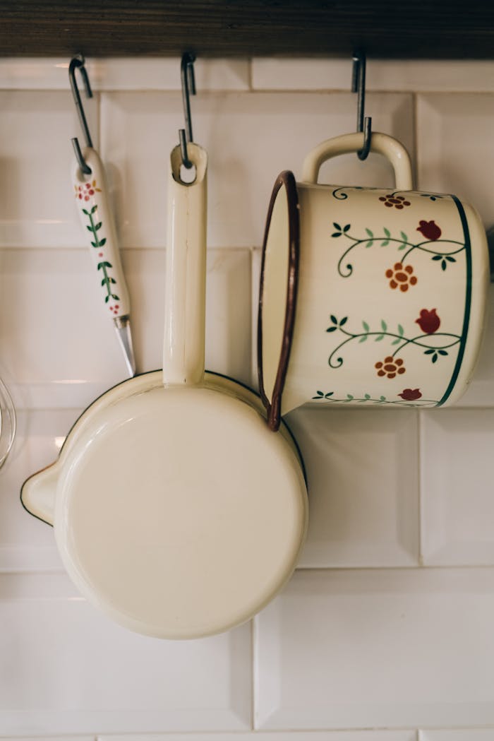A cozy display of vintage kitchen utensils hanging against a white tiled wall, showcasing a rustic charm.