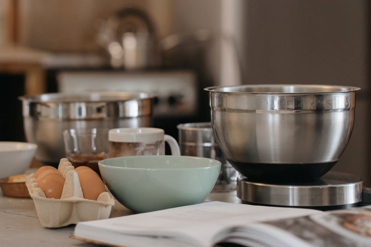 A cozy kitchen setup with baking bowls, eggs, and kitchen utensils for a comforting cooking experience.